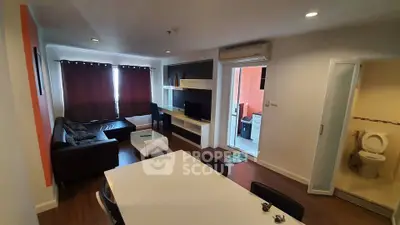 Modern living room with dining area and balcony access, featuring sleek furniture and natural light.
