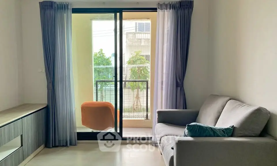 Modern living room with balcony view, featuring a cozy sofa and stylish decor.