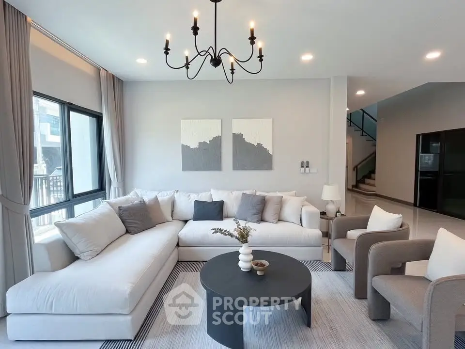 Elegant living room with modern decor, large windows, and stylish furniture in a contemporary home.