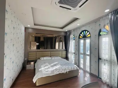 Luxurious bedroom with elegant decor and large windows offering natural light.