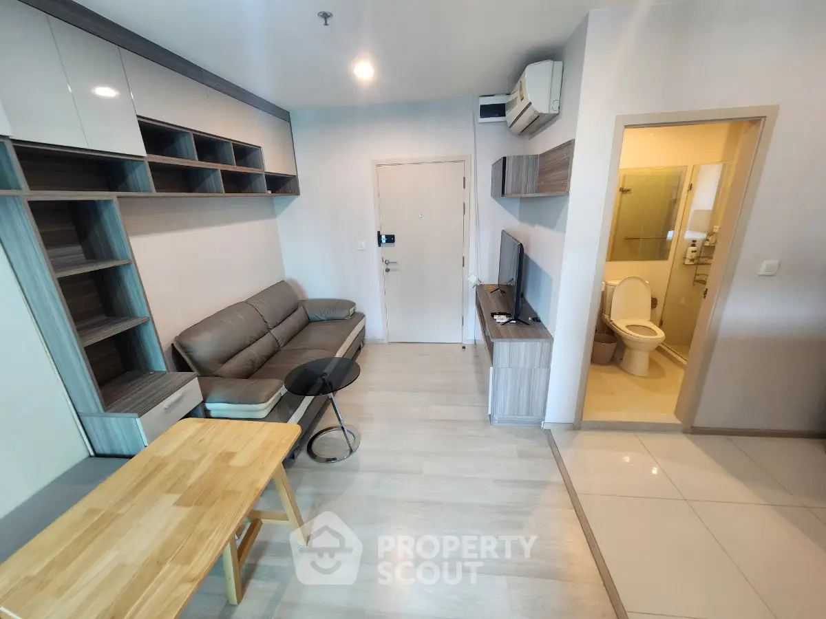 Modern living room with open layout and stylish furniture, featuring a cozy sofa and sleek TV setup.