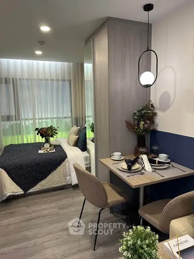 Modern studio apartment with cozy dining area and stylish bedroom decor.