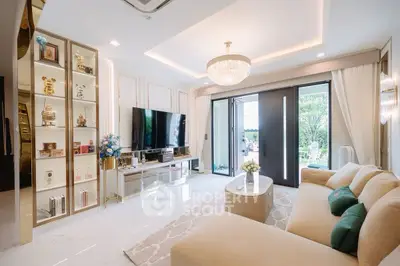 Luxurious living room with elegant decor and large TV, opening to a scenic view.