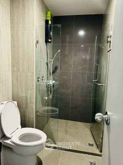 Modern bathroom with glass shower enclosure and sleek tile design.
