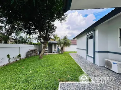 Charming backyard with lush green lawn and modern exterior, perfect for relaxation and outdoor activities.