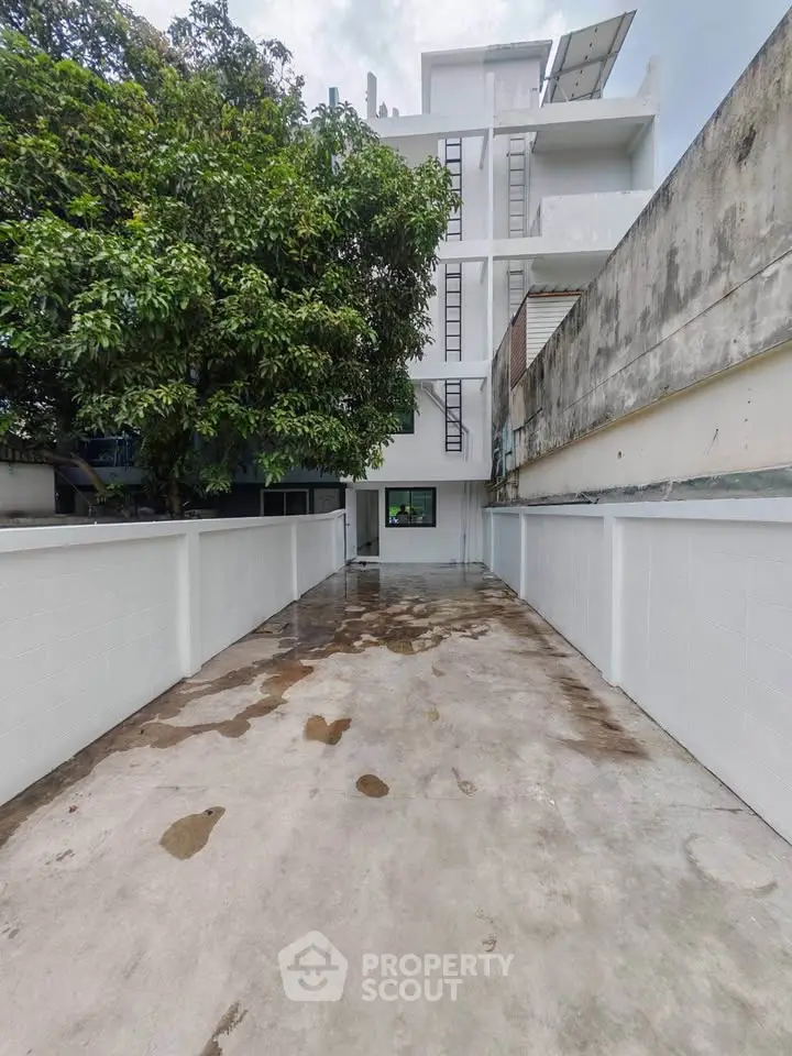 Modern building exterior with clean pathway and lush greenery