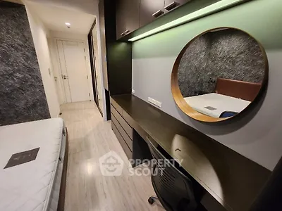 Modern bedroom with stylish workspace and round mirror, featuring sleek design and ample storage.