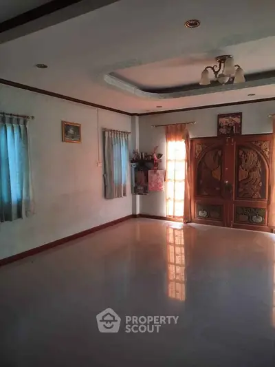 Spacious living room with elegant wooden doors and natural light