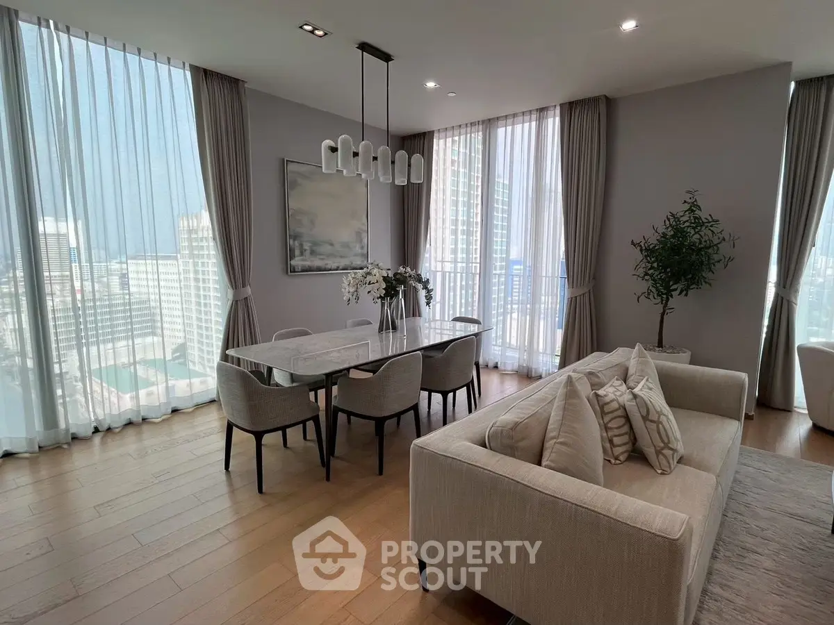 Luxurious modern living room with dining area and city view, featuring elegant decor and floor-to-ceiling windows.