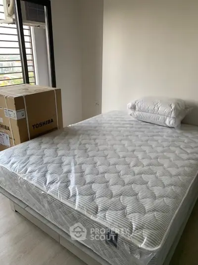Modern bedroom with new mattress and Toshiba appliances in bright apartment