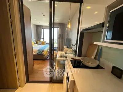 Modern open-layout kitchen leading to a cozy bedroom with stylish decor and natural light.