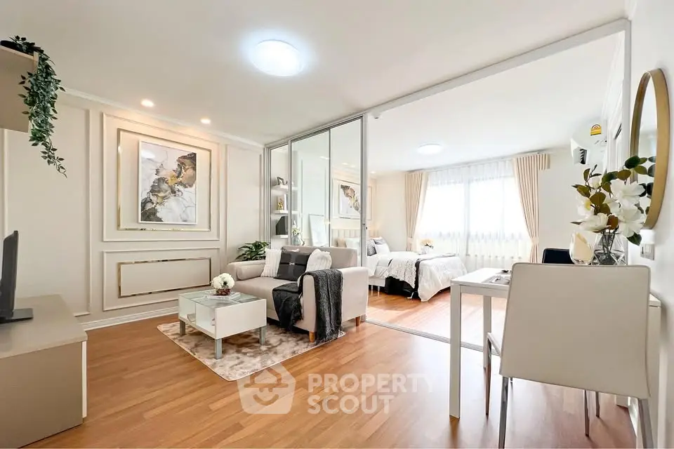Modern open-plan living room and bedroom with elegant decor and natural light.
