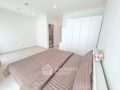 Spacious modern bedroom with elegant decor and ample natural light