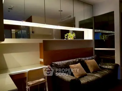 Modern living room with black leather sofa and mirrored wall accents.