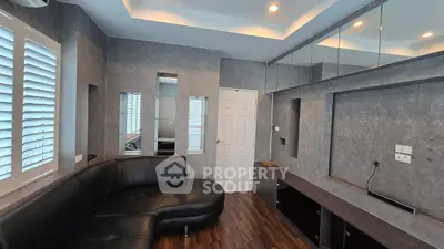 Modern living room with sleek black sofa and mirrored wall accents
