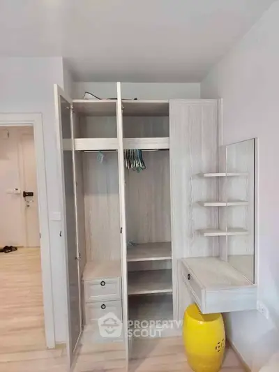 Modern wardrobe with open doors in a stylish bedroom, featuring light wood finish and built-in shelves.