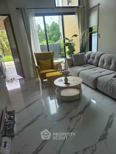 Modern living room with stylish furniture and large windows offering natural light.