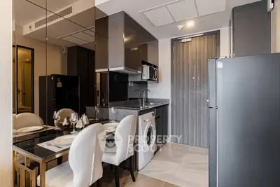 Modern kitchen with dining area, featuring sleek cabinetry and built-in appliances.