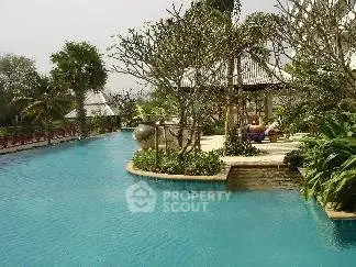 Luxurious resort-style pool with lush greenery and serene surroundings