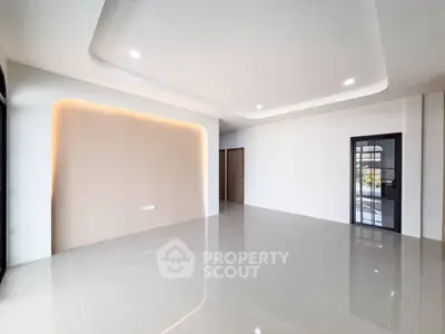 Spacious modern living room with sleek tile flooring and ambient lighting