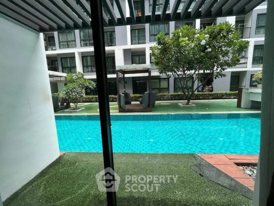 Luxurious condo with pool view, lush greenery, and modern architecture for serene living.