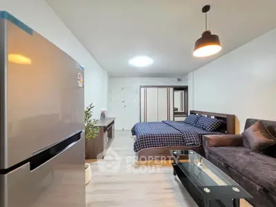 Modern studio apartment with stylish furnishings and open layout, featuring a cozy bed, sleek sofa, and contemporary decor.