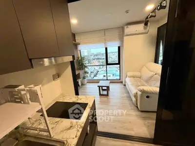 Modern compact apartment with open kitchen and cozy living area, featuring city views.