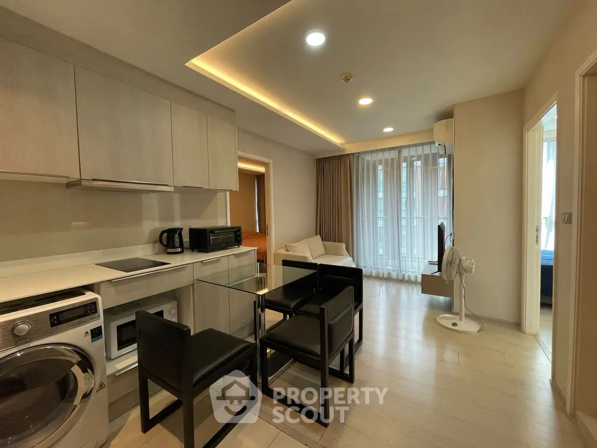 Modern open-plan kitchen and living area with sleek furnishings and natural light.
