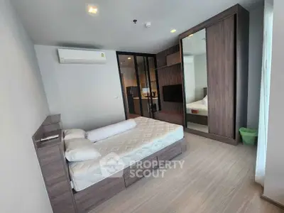 Modern bedroom with sleek wooden furniture and large mirror wardrobe in a stylish apartment.