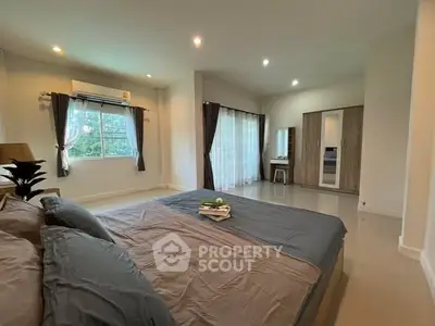 Spacious bedroom with large windows and modern decor