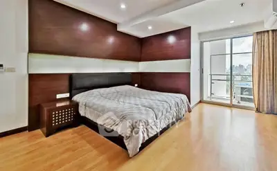 Spacious modern bedroom with city view and balcony access