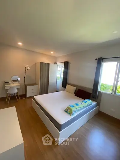 Spacious bedroom with modern furniture and natural light