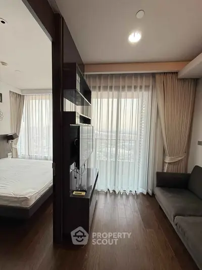 Modern apartment interior with floor-to-ceiling windows and elegant curtains, featuring a cozy living area and bedroom.