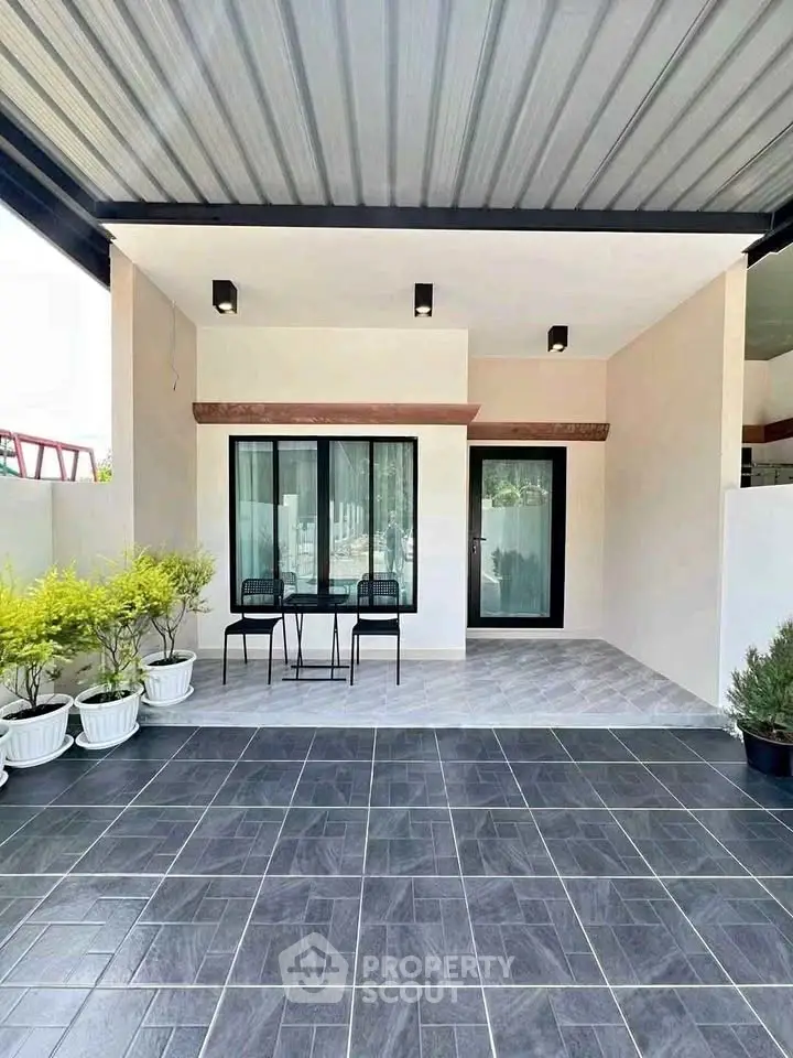 Modern home exterior with covered patio and stylish seating area