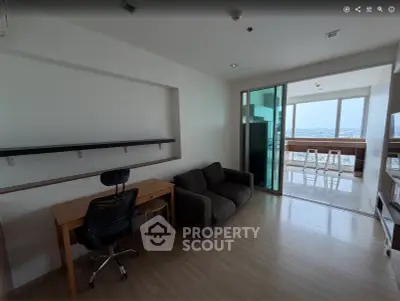 Modern apartment with study area and bright living space featuring large windows and city view.