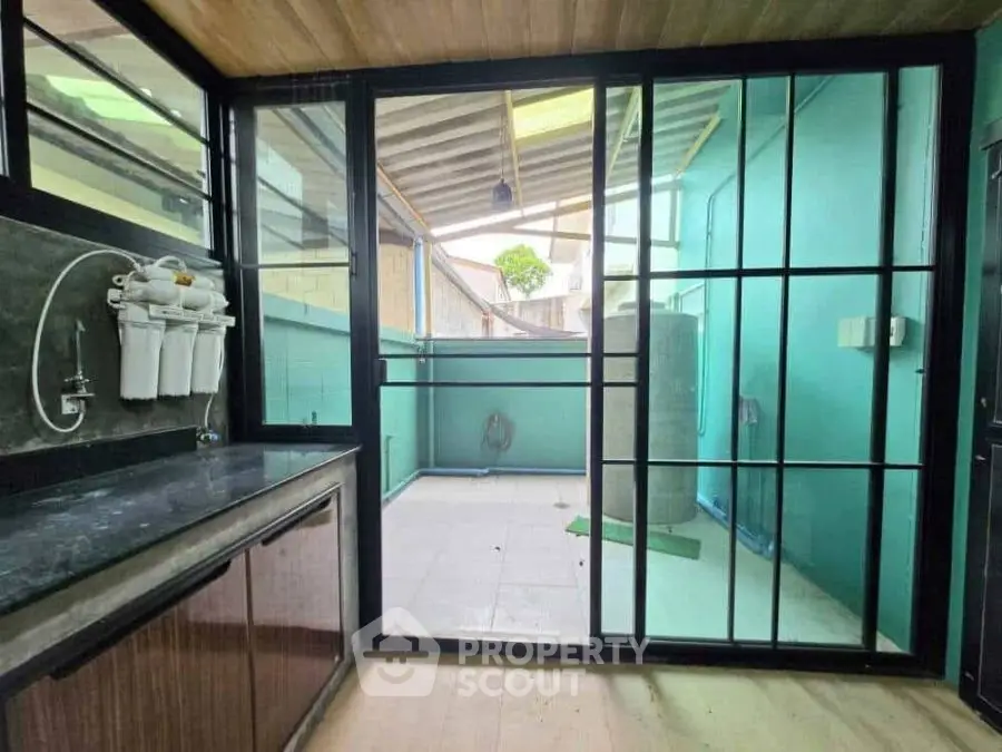 Modern utility area with water filtration system and outdoor access