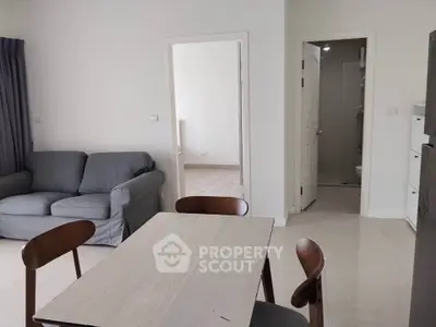 Modern apartment interior with cozy living room and dining area, featuring neutral tones and minimalist design.