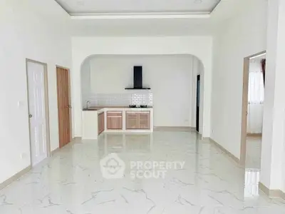 Spacious open-plan kitchen with modern design and marble flooring, perfect for contemporary living.