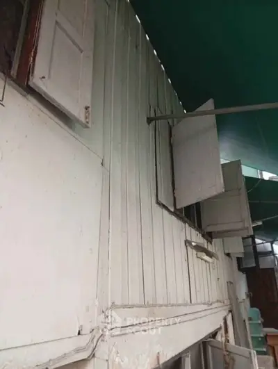 Charming rustic exterior with vintage wooden shutters and weathered siding, perfect for renovation enthusiasts.