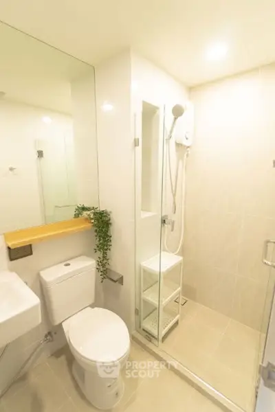 Modern bathroom with glass shower and sleek fixtures in a bright, minimalist design.