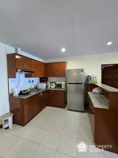 Spacious kitchen with modern appliances and ample storage in a cozy home.