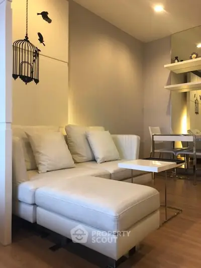 Modern living room with elegant white sofa and stylish decor in a cozy apartment setting.