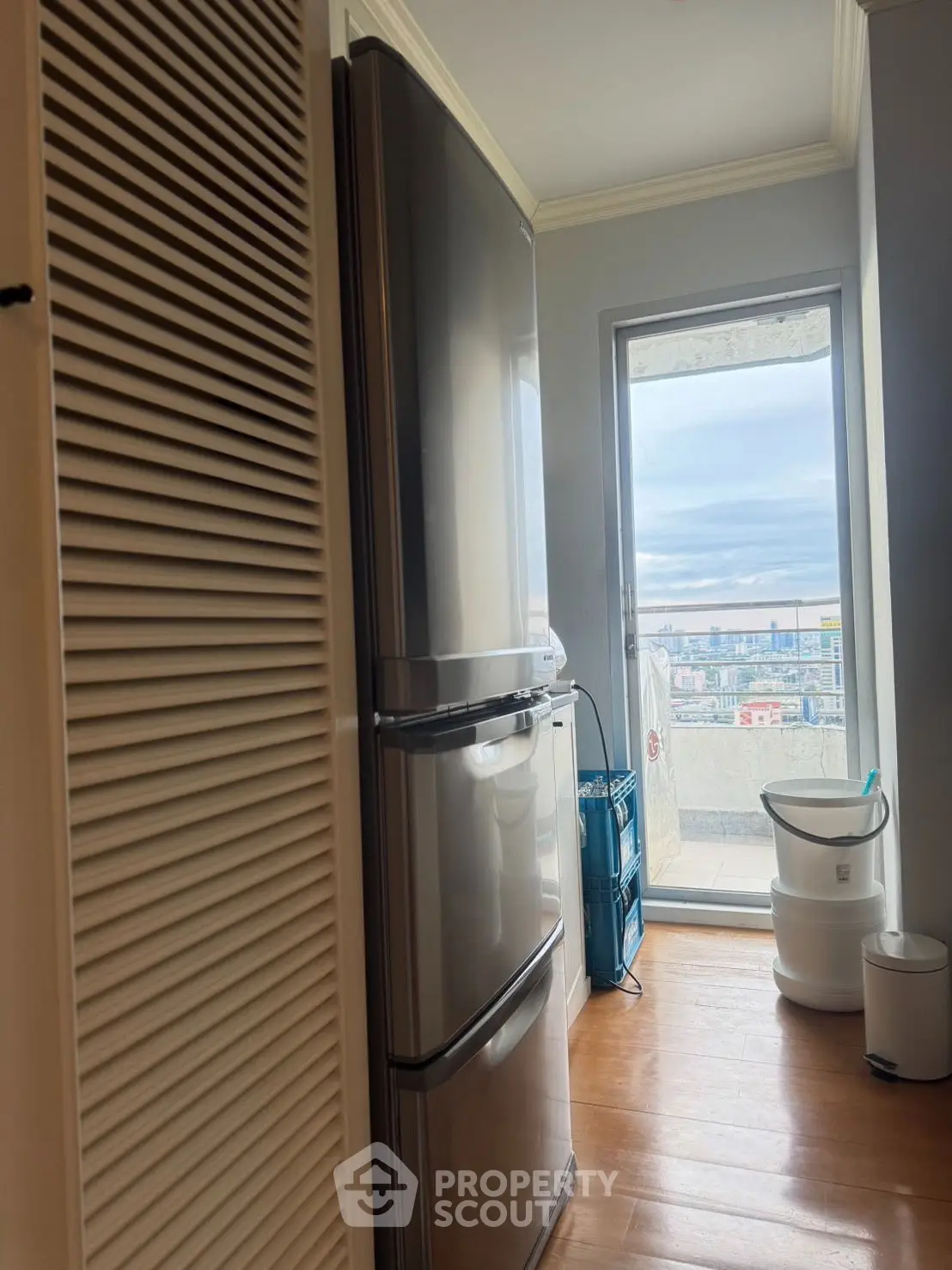 Modern kitchen with sleek fridge and balcony view, perfect for urban living.