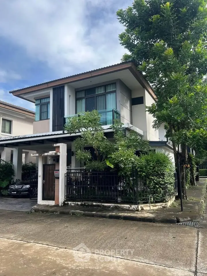 Charming two-story house with lush greenery and modern design in a serene neighborhood.
