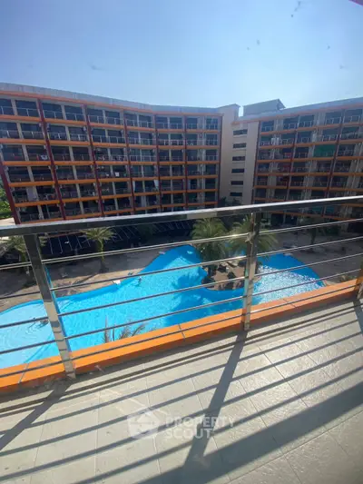Spacious balcony with stunning pool view in modern apartment complex