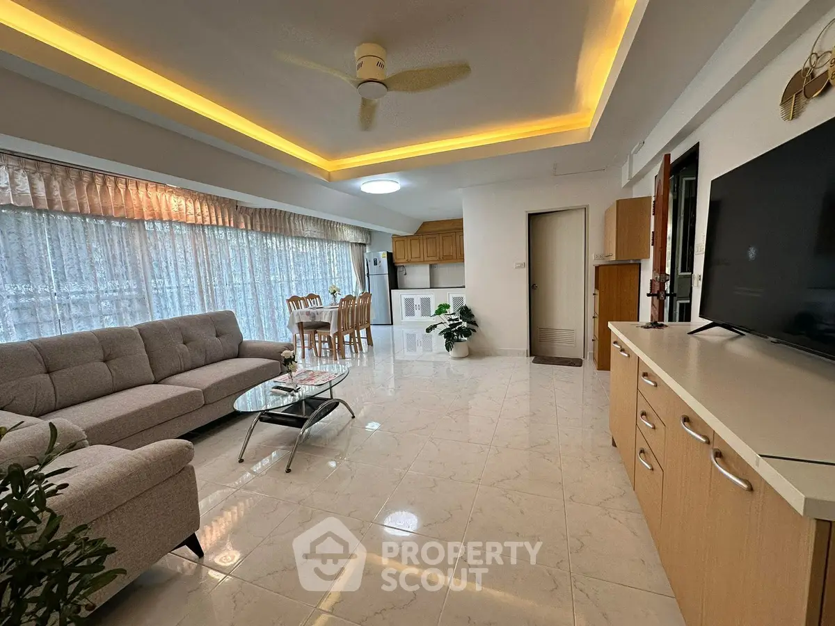 Spacious living room with modern decor and open kitchen layout