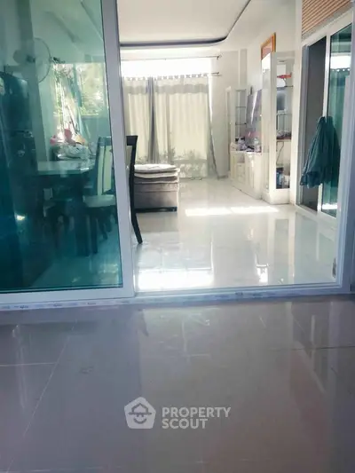 Spacious living room with glass doors and abundant natural light