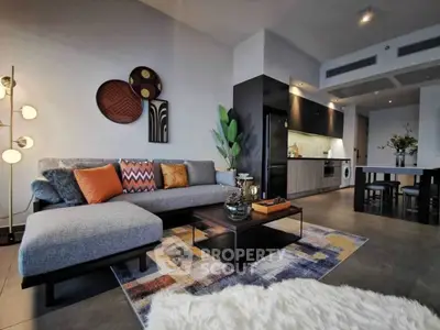 Modern living room with stylish decor and open kitchen layout, featuring cozy seating and contemporary design.