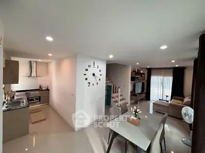 Modern open-plan living and dining area with stylish kitchen and cozy seating.