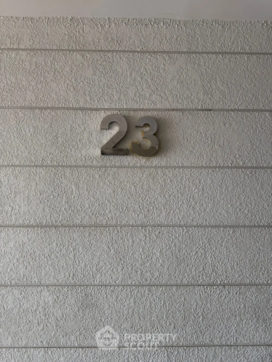Modern textured wall with number 23, ideal for contemporary real estate listings.